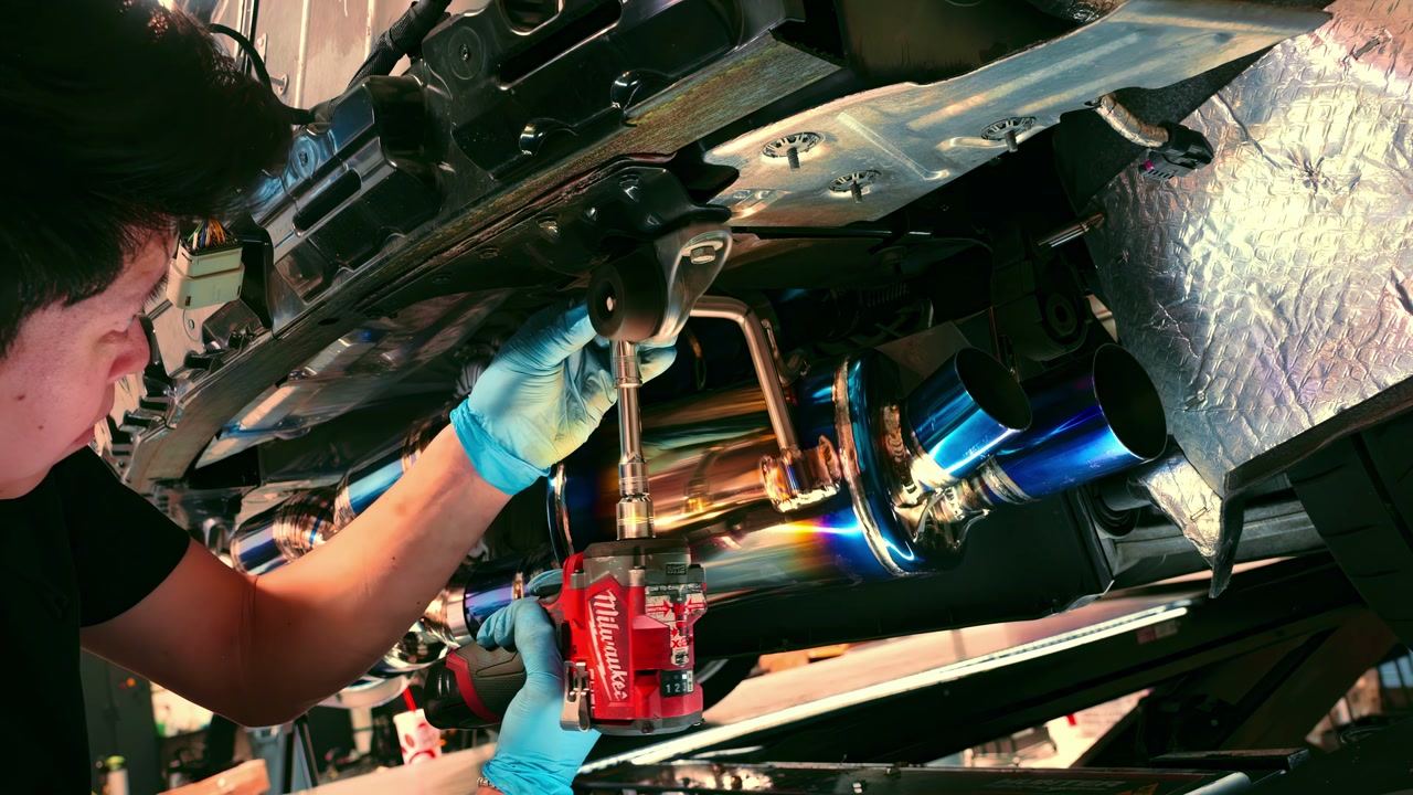 A technician working on the Corvette C8 exhaust during installation